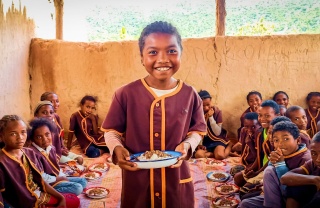 a boy holds a plate of food