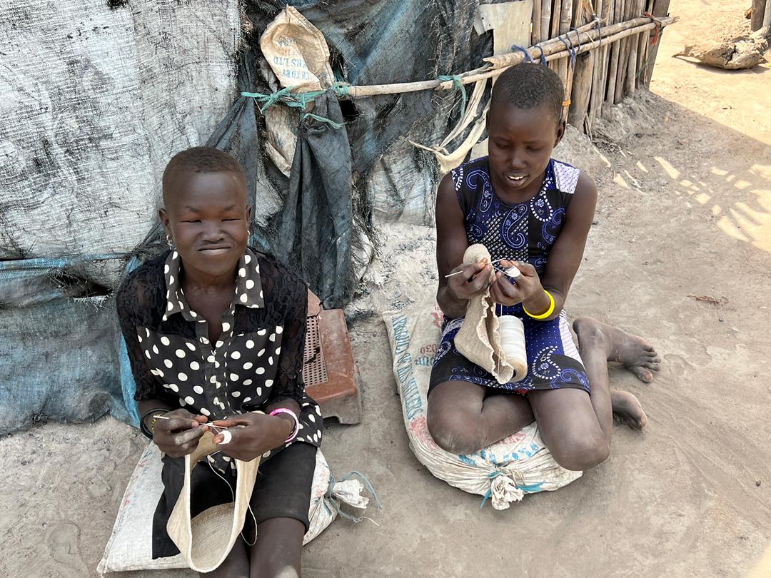 two girls kneeling on the ground