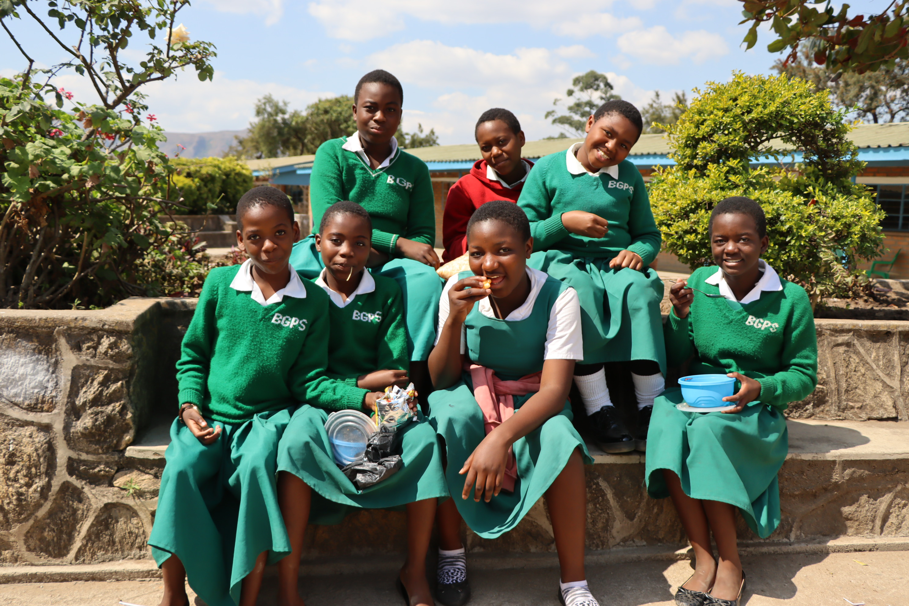 a group of class mates posing for a photo outdoors