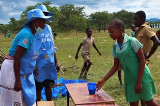 girl collecting blue mug from an outdoor table