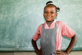 a young girl posing for a photo in front of a chalkboard