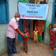 Man handing over bowl of food to young child