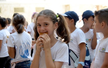 A girl smiles as she eats in Syria