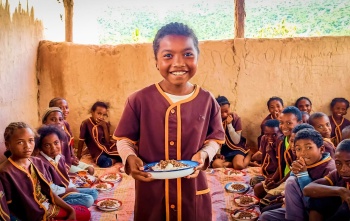 a boy holds a plate of food