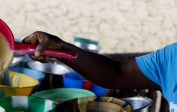 Volunteer serving porridge