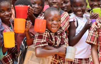Children smiling with mugs 