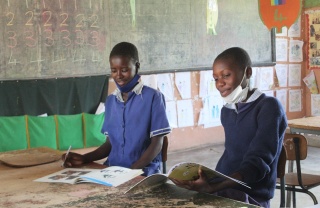 Two children from Zambia learning and reading in their classroom.