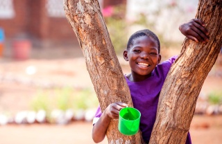 A young boy rest against a tree