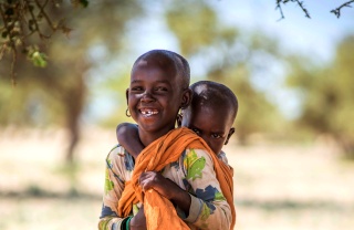 A child carries his sibling