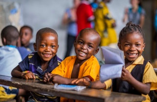 3 children smiling in a classroom