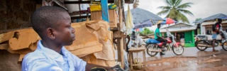 Momo, a child from Liberia working to repair shoes to earn extra money for him and his family.