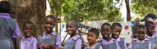 Children in Malawi waiting to be served Mary's Meals in their place of education.