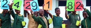 Children in Zimbabwe lined up to celebrate Mary's Meals reaching a new number of children being served nutritious school meals.