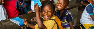 Children laughing together in a classroom in Liberia