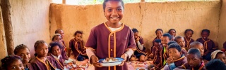 a boy holds a plate of food