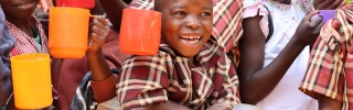 Children smiling with mugs 