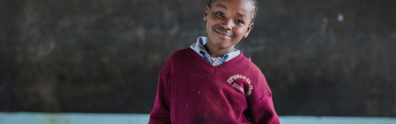 Student in front of blackboard in Kenya