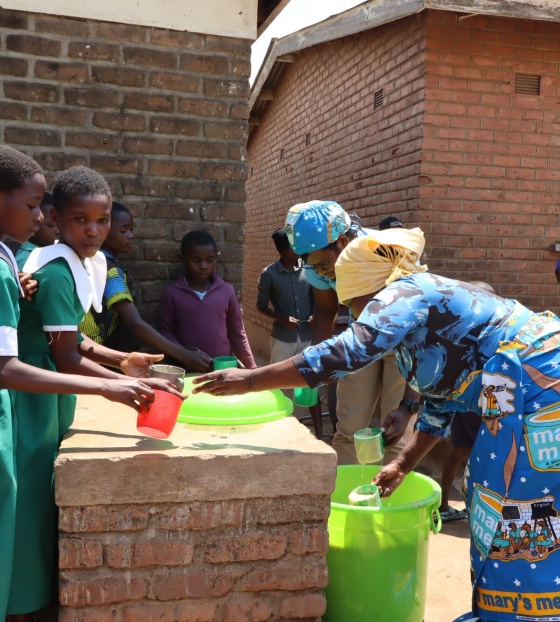 Children being served Mary's Meals at school in Malawi. 