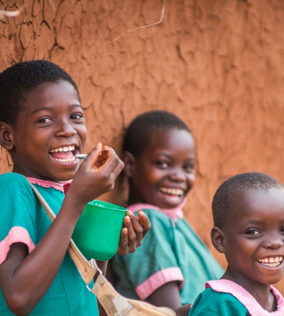 Children eat food together at school in Malawi