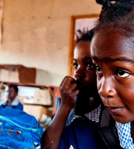 A young girl takes notes in class