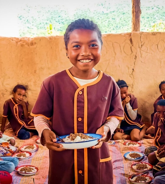 a boy holds a plate of food