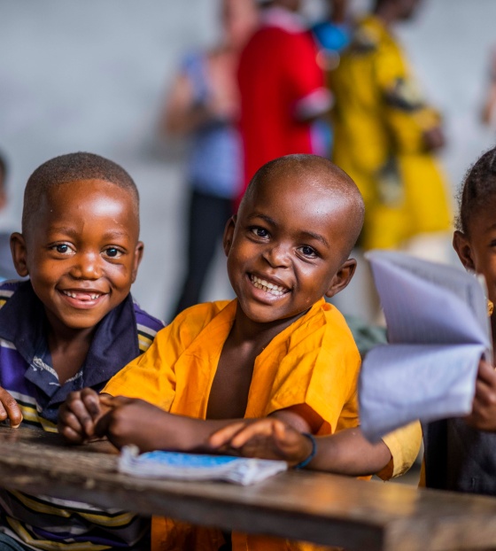 3 children smiling in a classroom