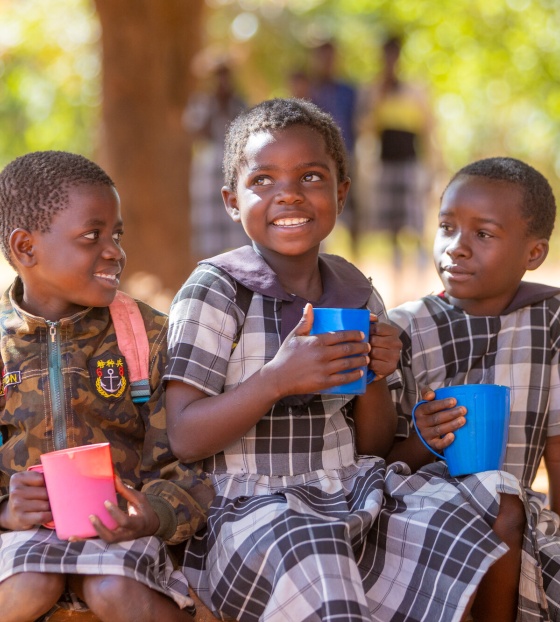 Children smiling with mugs 