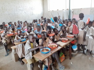 Students in class eating their Mary's Meals