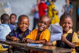 3 children smiling in a classroom
