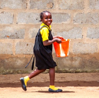 a girl carries a bucket of water