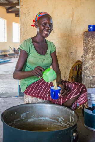 Volunteer pouring porridge