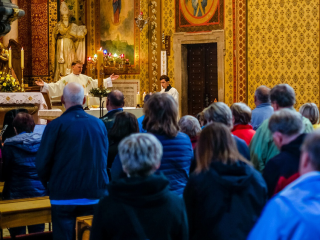 Image of a priest reading a passage from the bible.